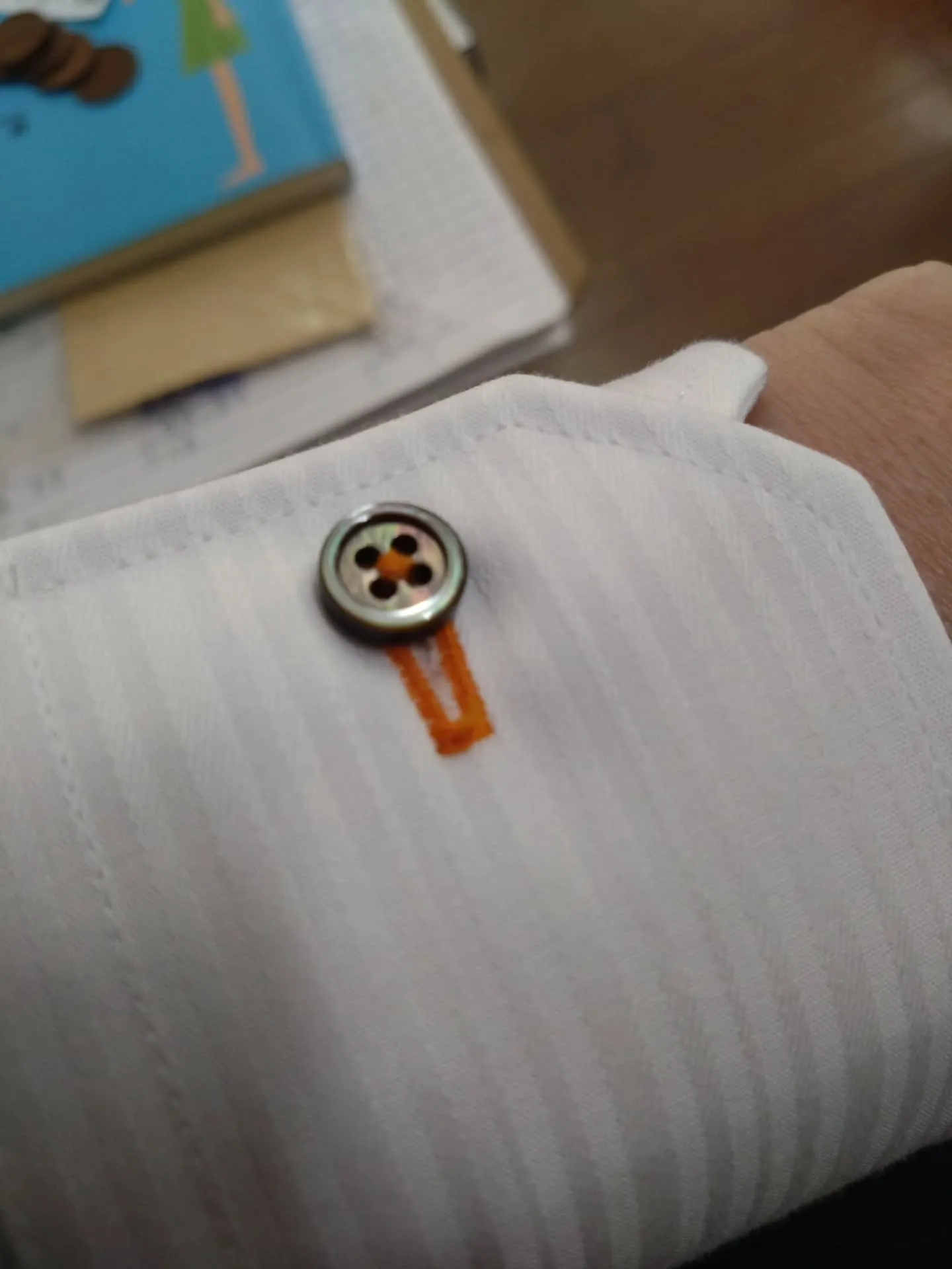 今回のオーダーシャツのこだわりは、オレンジの糸と黒い貝ボタン...